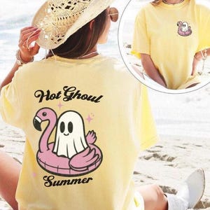 May include: A yellow t-shirt with a ghost on a pink flamingo float. The text "Hot Ghoul Summer" is printed on the back of the shirt.