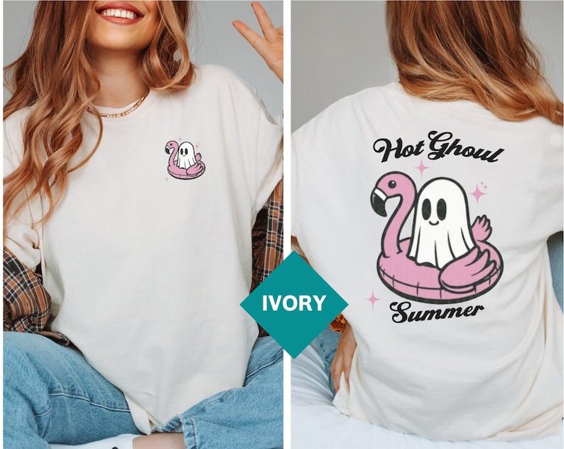 May include: Ivory t-shirt with a cartoon ghost on a pink flamingo inflatable. The back of the shirt has the words "Hot Ghoul Summer" above the flamingo and ghost design. The t-shirt has a loose fit.