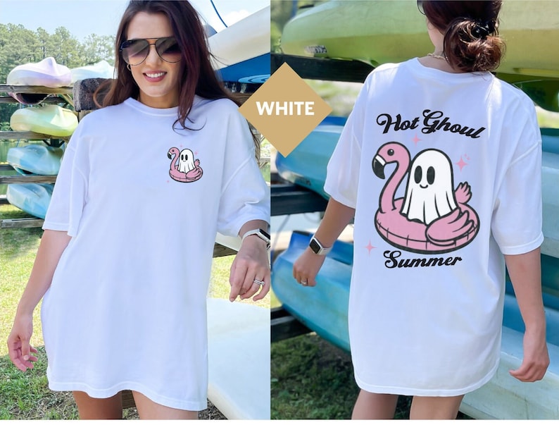 May include: White t-shirt with a cartoon ghost on a pink flamingo float. The back of the shirt has the words "Hot Ghoul Summer" above the ghost and flamingo design. A fun summer themed top.