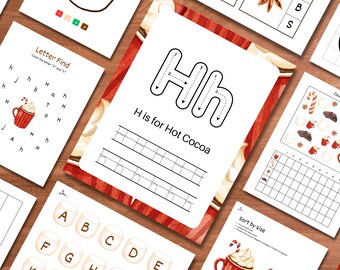May include: A selection of educational worksheets with a winter theme. The worksheets feature illustrations of hot cocoa, candy canes, and marshmallows. One worksheet says "H is for Hot Cocoa" and another says "Letter Find". The pages are arranged on a wooden surface.