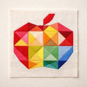 Puede incluir: Un bloque de tela cuadrado para acolchar con un diseño geométrico de manzana construido a partir de parches triangulares multicolores. La forma de la manzana se compone de piezas de tela rojas, naranjas, amarillas, verdes y azules sobre un fondo blanco roto.