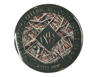 May include: A green and gold coin with a camouflage pattern and the text "Just No Addicting Recovery Need Ever Or Die" around the edge. The center of the coin features a green diamond with the letters "NA" in gold.