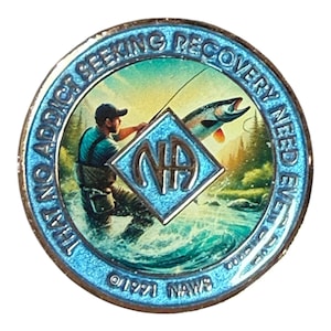 Könnte beinhalten: Eine runde Metallmedaille mit blauem Rand und der Aufschrift THAT NO ADDICT SEEKING RECOVERY NEED EVER DIE. Die Mitte zeigt eine Person beim Angeln in einem Fluss mit einem springenden Fisch und einem rautenförmigen NA-Logo. Unten steht 1971 NAWS.