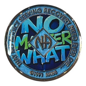 Blue and green Narcotics Anonymous medallion with graffiti-style text reading ‘No Matter What’ around the NA symbol, bordered by the phrase ‘That no addict seeking recovery need ever die.’