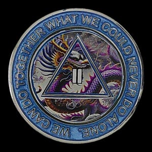 Può includere: Un medaglione metallico circolare con un bordo blu e il testo "WE CAN DO TOGETHER WHAT WE COULD NEVER DO ALONE". Il centro mostra un'illustrazione di un drago viola e oro dietro un triangolo blu contenente il numero romano II.