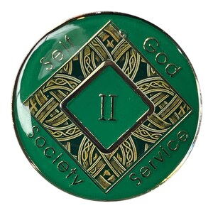 Narcotics Anonymous Celtic knot medallion in green enamel with intricate gold knotwork, Roman numeral II in the center, and the words “Self, God, Society, Service,” symbolizing two years clean and the interconnected journey of faith, unity, and recovery.