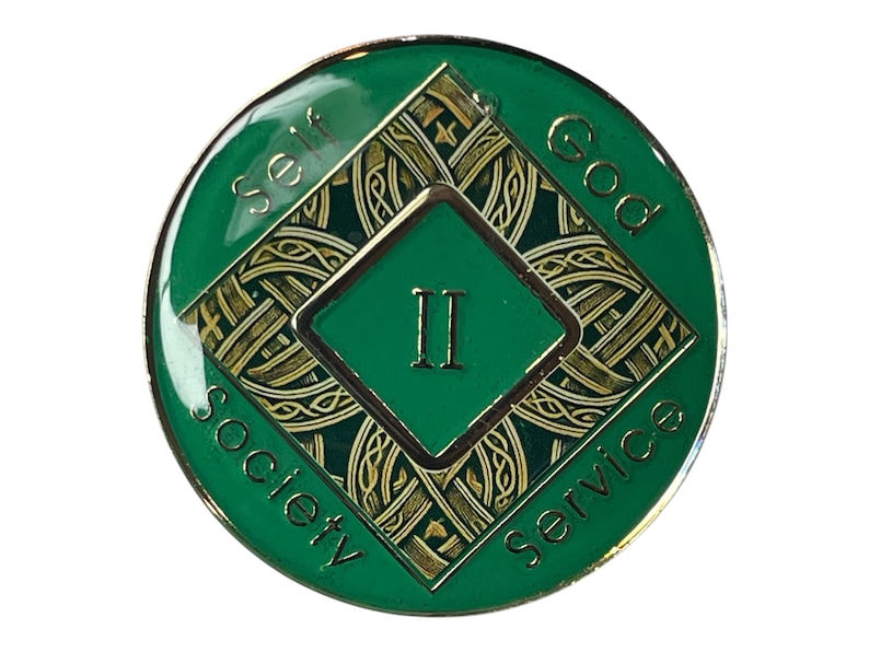Narcotics Anonymous Celtic knot medallion in green enamel with intricate gold knotwork, Roman numeral II in the center, and the words “Self, God, Society, Service,” symbolizing two years clean and the interconnected journey of faith, unity, and recovery.