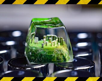 May include: A green resin keycap with a miniature stonehenge structure inside. The keycap is sitting on a black keyboard.