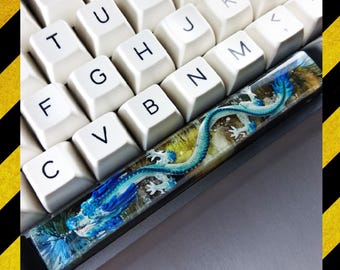 May include: A white mechanical keyboard with a blue and green dragon keycap. The keycap is made of resin and has a 3D effect.