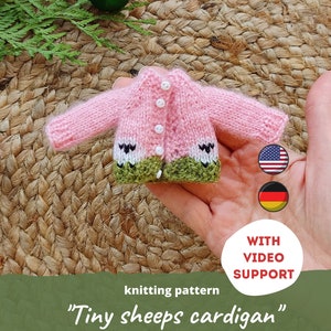 May include: Knitting pattern for a tiny pink and green cardigan with white buttons. The pattern includes video support and is available in English and German.