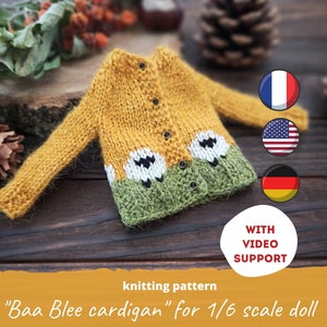 May include: Knitting pattern for a yellow, green, and white cardigan with sheep designs. The pattern is for a 1/6 scale doll. The text "Baa Blee cardigan for 1/6 scale doll" is written on the image. The image also includes the text "WITH VIDEO SUPPORT".