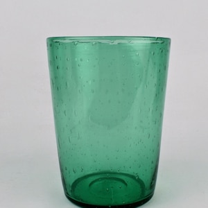 May include: A green glass tumbler with a textured surface. The glass has small air bubbles throughout.