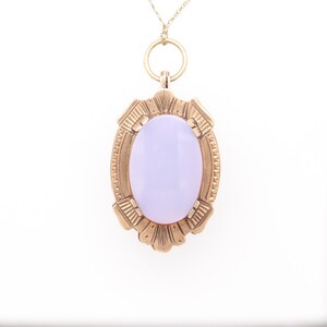 May include: A gold pendant necklace with a lavender oval gemstone set in a detailed gold frame.