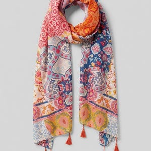 May include: A patterned scarf in a patchwork design, featuring floral and geometric motifs in pink, orange, blue, and yellow. The scarf has orange tassels at the ends. This accessory is ideal for adding a vibrant touch to any outfit. The scarf is approximately 180cm in length.