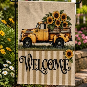 May include: A garden flag featuring a vintage yellow truck filled with sunflowers. The truck is set against a beige background with vertical stripes. The word "WELCOME" is written in elegant black script.