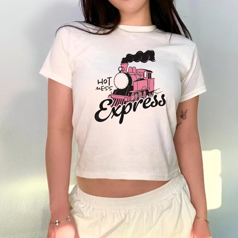 May include: White cropped t-shirt with a pink and black train graphic and the text "Hot Mess Express".