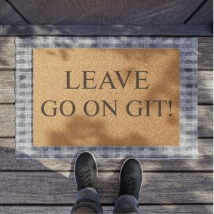 May include: A brown doormat with a white border and the text "LEAVE GO ON GIT!" printed in black.