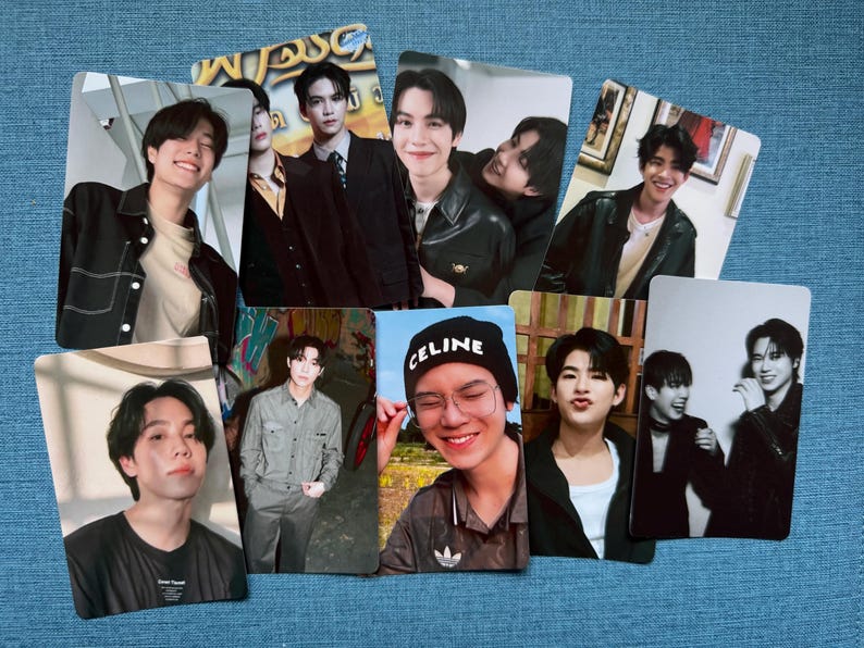 May include: A collection of eight photo cards featuring images of young men in various poses and outfits. The cards display a range of expressions, from smiles to more serious looks. Some cards have text, including the word "CELINE" on a black beanie.