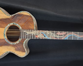 May include: Acoustic guitar with a detailed dragon design. The body is light brown with a dark brown stripe, and the fretboard features a colorful dragon motif. The headstock has a carved dragon and gold tuning pegs.