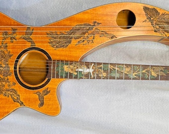 May include: A unique, custom-made wooden guitar with a double neck design. The instrument features intricate etched artwork of birds and foliage across its warm, brown surface. The guitar has a round sound hole and a bridge with strings.