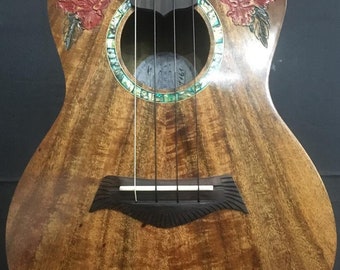 May include: A brown ukulele with a floral design and a mother-of-pearl inlay around the sound hole. The ukulele has a dark brown wooden body and a light brown wooden neck. The floral design is carved into the wood and features red flowers and green leaves.
