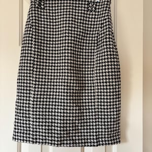 Puede incluir: Una falda de pata de gallo en blanco y negro. La falda es de estilo lápiz y está hecha de un tejido tejido.