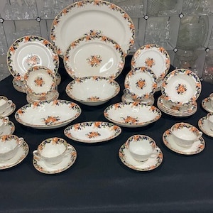 Puede incluir: Un juego de vajilla de porcelana vintage con flores y ribete azul y dorado. El juego incluye platos, cuencos, tazas y platillos.