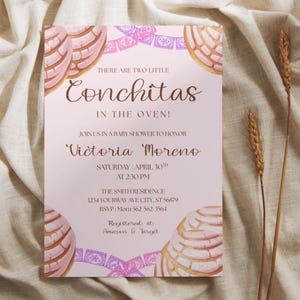 May include: A baby shower invitation with a pink background and the text "There are two little Conchitas in the oven!" The invitation includes details for Victoria Moreno's baby shower, with concha bread illustrations.