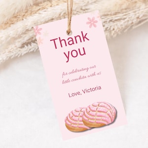 May include: A pink gift tag with the words "Thank you" in a dark pink font. The tag includes the text "for celebrating our little conchita with us" and "Love, Victoria". Two concha pastries are at the bottom.