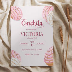 May include: A rectangular invitation with a pink and white concha pastry design. The invitation text reads "A little Conchita sweet and fun. Come celebrate VICTORIA is turning ONE!" with date, time, and RSVP information.