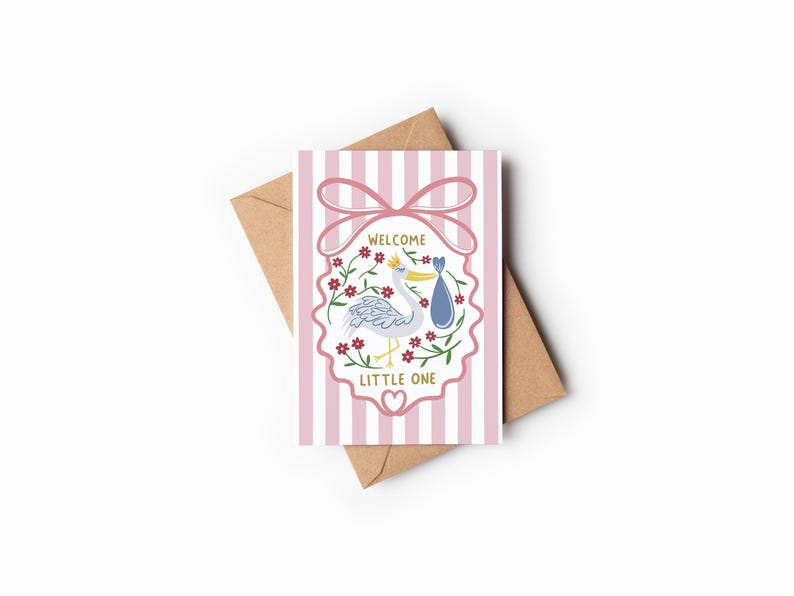 May include: A baby shower greeting card with a stork carrying a baby in a blue bundle. The card has pink and white stripes and the words "WELCOME LITTLE ONE". The card is on a brown envelope.