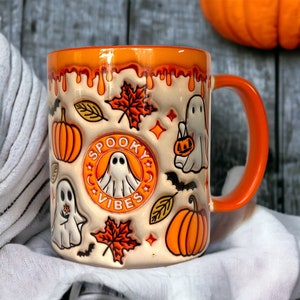 Orange coffee mug with ghosts, pumpkins and other Halloween motifs