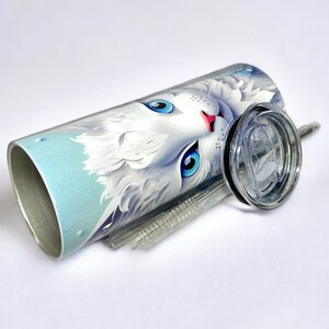 Edelstahl-Tumbler 590 ml mit weißer Katze und blauen Blumen, doppelwandig isoliert, inklusive Deckel und Edelstahl-Strohhalm. Hält Getränke 12 Stunden kalt oder 6 Stunden heiß. Hochwertig sublimiert, langlebig und wiederverwendbar. Perfektes Geschenk für Katzenliebhaber und Tierfreunde.