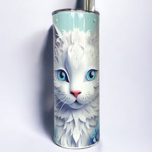 Edelstahl-Tumbler 590 ml mit weißer Katze und blauen Blumen, doppelwandig isoliert, inklusive Deckel und Edelstahl-Strohhalm. Hält Getränke 12 Stunden kalt oder 6 Stunden heiß. Hochwertig sublimiert, langlebig und wiederverwendbar. Perfektes Geschenk für Katzenliebhaber und Tierfreunde.