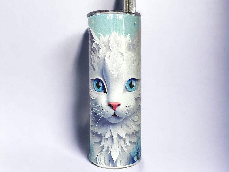 Edelstahl-Tumbler 590 ml mit weißer Katze und blauen Blumen, doppelwandig isoliert, inklusive Deckel und Edelstahl-Strohhalm. Hält Getränke 12 Stunden kalt oder 6 Stunden heiß. Hochwertig sublimiert, langlebig und wiederverwendbar. Perfektes Geschenk für Katzenliebhaber und Tierfreunde.