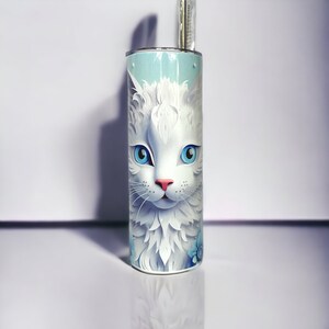 Edelstahl-Tumbler 590 ml mit weißer Katze und blauen Blumen, doppelwandig isoliert, inklusive Deckel und Edelstahl-Strohhalm. Hält Getränke 12 Stunden kalt oder 6 Stunden heiß. Hochwertig sublimiert, langlebig und wiederverwendbar. Perfektes Geschenk für Katzenliebhaber und Tierfreunde.