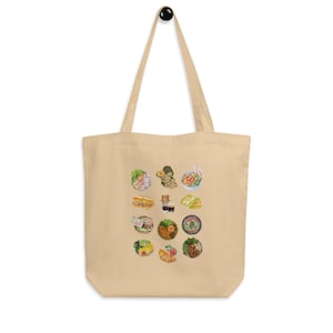 Può includere: Borsa tote beige con un'illustrazione ad acquerello di vari piatti asiatici. La borsa ha una forma rettangolare con due manici lunghi. Le illustrazioni di cibo includono noodles, panini e altre delizie culinarie.