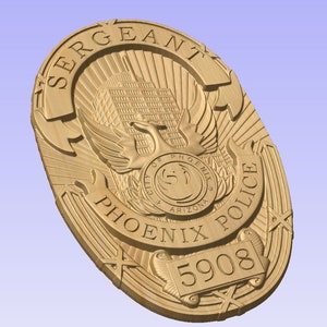 May include: A gold-colored metal police badge with the words "SERGEANT" and "PHOENIX POLICE" around the perimeter. The badge features a stylized phoenix bird with wings spread, a building, and the words "CITY OF PHOENIX ARIZONA". The badge number "5908" is displayed on a scroll at the bottom.
