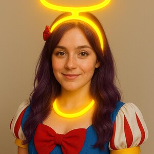 May include: A woman wearing a yellow halo and necklace, with a red bow and a blue and white dress. The halo and necklace glow brightly. The woman has purple hair and is smiling.
