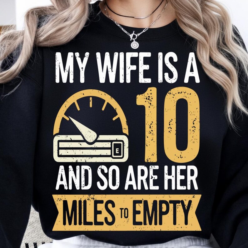 May include: Black sweatshirt with the text "MY WIFE IS A 10 AND SO ARE HER MILES TO EMPTY" in white and yellow. The design includes a speedometer graphic.
