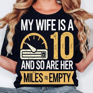 May include: Black t-shirt with white and yellow graphic text that reads "MY WIFE IS A 10 AND SO ARE HER MILES TO EMPTY." The design includes a speedometer and the number 10.