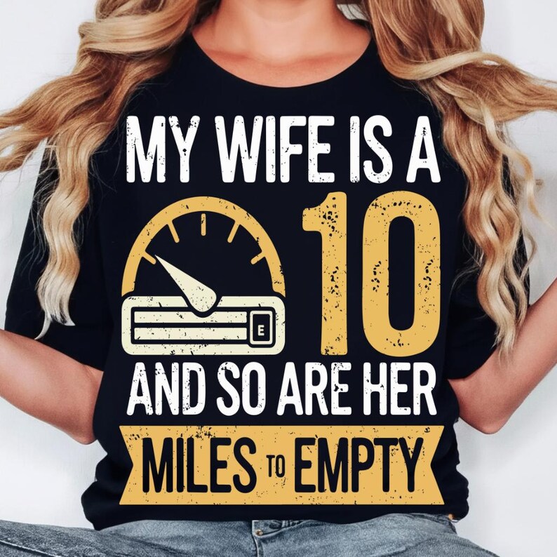 May include: Black t-shirt with white and yellow graphic text that reads "MY WIFE IS A 10 AND SO ARE HER MILES TO EMPTY." The design includes a speedometer and the number 10.