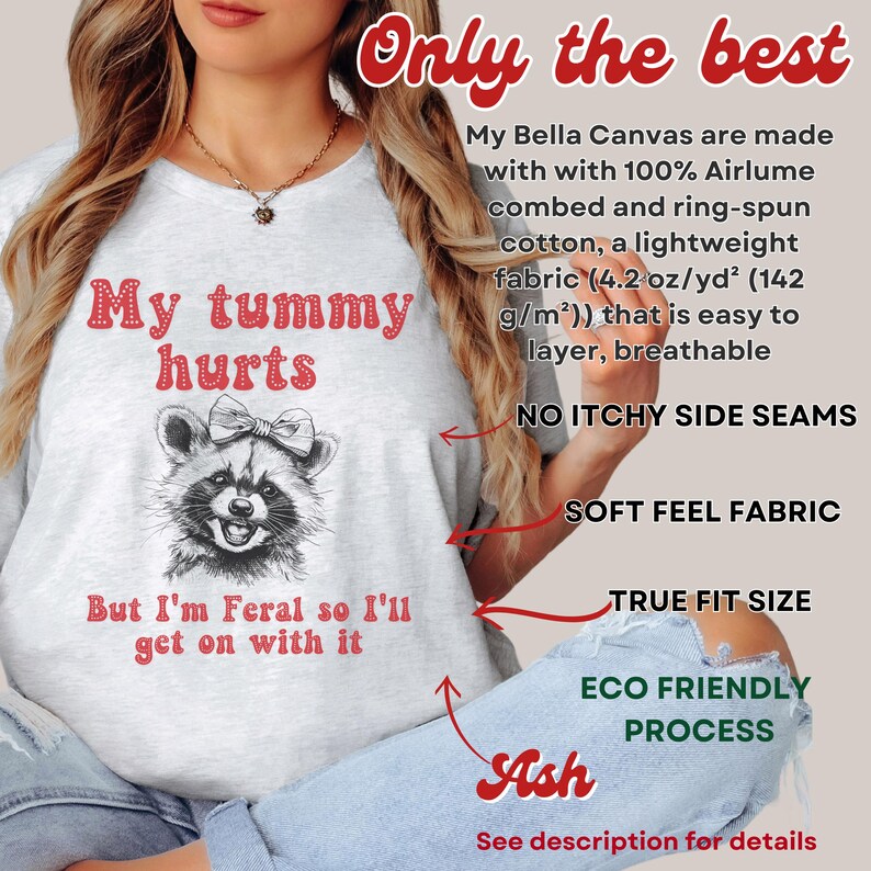 The Ash t-shirt with the text “my tummy hurts but I’m feral so I’ll get on with it' and a raccoons head. The text 'Only the best' is in red at the top of the image. The text 'No itchy side seams', 'Soft feel fabric', 'True fit size', 'Eco friendly process'