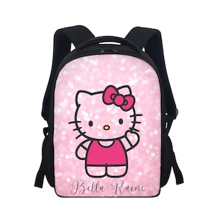 May include: Pink backpack featuring a Hello Kitty design with a pink bow and outfit, set against a sparkly background. The backpack has black straps and side pockets, with the name "Bella Raine" in cursive script.