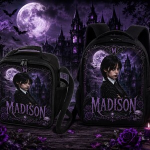 Puede incluir: Una mochila negra y una bolsa de almuerzo a juego, ambas con un gráfico de una persona de pelo oscuro, un castillo gótico, una luna llena y el nombre MADISON en letras moradas. Los diseños incluyen rosas moradas y detalles de calaveras.