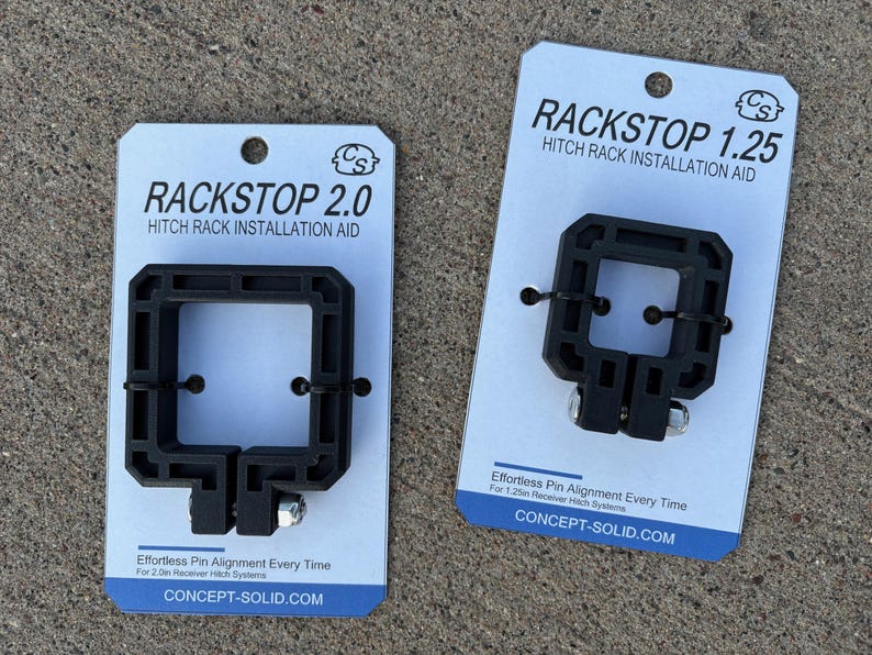 Puede incluir: Dos ayudas de instalaci&oacute;n de portabicicletas negras, etiquetadas como "RACKSTOP 2.0" y "RACKSTOP 1.25", se muestran en tarjetas blancas. Las ayudas tienen un dise&ntilde;o cuadrado con una abertura central y est&aacute;n dise&ntilde;adas para una alineaci&oacute;n sencilla de los pasadores. Las tarjetas incluyen el sitio web CONCEPT-SOLID.COM.