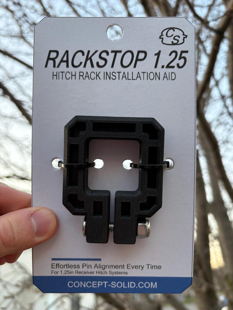 Puede incluir: Ayuda de instalaci&oacute;n de portaequipajes Rackstop 1.25 negro sobre una tarjeta blanca. El texto en la tarjeta dice "Effortless Pin Alignment Every Time" y "For 1.25in Receiver Hitch Systems". El producto est&aacute; dise&ntilde;ado para ayudar con la instalaci&oacute;n del portaequipajes.
