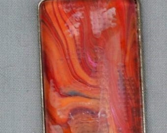 May include: A silver pendant with a rectangular orange, red, and white marbled glass insert.