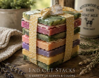May include: A stack of rectangular soap bars in various colors including green, pink, purple, and yellow, tied together with a yellow and white floral patterned ribbon. The text on the image reads: END CUT STACKS A VARIETY OF SCENTS & COLORS.