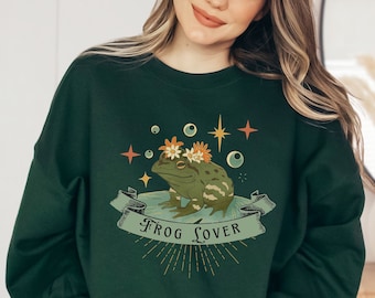 May include: A dark green sweatshirt with a frog wearing a flower crown and the text "Frog Lover" in a vintage style.